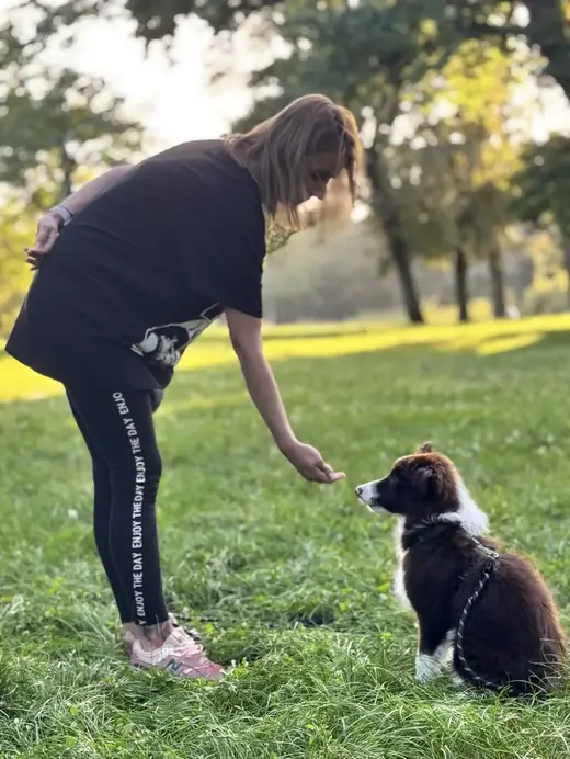 Instruktorka Dogs Friends uczy szczeniaka skupienia na zajęciach w Parku Cytadela w Poznaniu